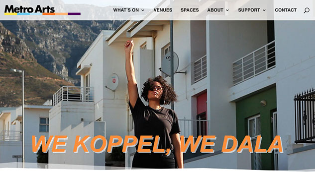 Website Banner Image with orange text We Koppel We Dala on a photo of woman standing below housing with one fist raised high wearing all black.